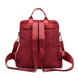 Burgundy corduroy backpack showing adjustable shoulder straps and top handle from back view