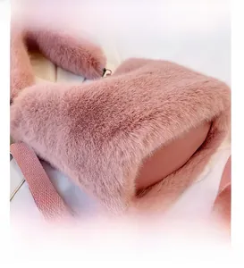 Detail of pink faux fur bag featuring woven shoulder strap and golden metal buckle
