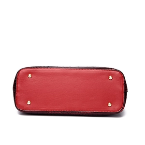 Bottom view of red bucket bag with gold metal feet and crocodile embossed pattern