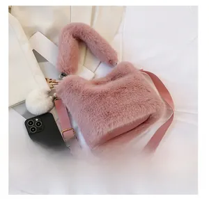Pink plush bucket bag size comparison with a smartphone showing compact capacity