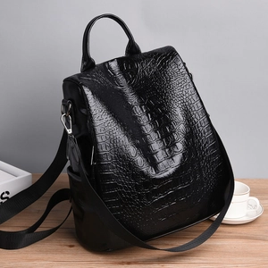 Women's black faux crocodile leather backpack with a high-shine finish and multiple straps
