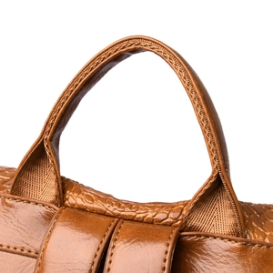 Detail of caramel brown leather handle with crocodile pattern and reinforced stitching