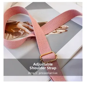 Adjustable pink woven shoulder strap with gold buckle detail on fashion magazine