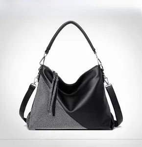 Détail frontal du sac bandoulière noir avec triangle en strass et pompons scintillants