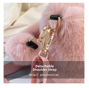 Detail showing the detachable gold metal hook and pink plush strap of the bucket bag