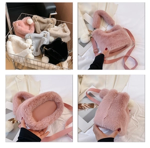 Detail view of plush bucket bag showing soft texture, pearl charm and removable strap