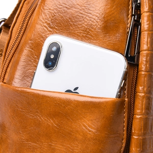 Close-up of brown faux leather backpack showing litchi and crocodile texture details