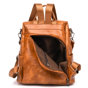 Detail view of brown faux leather backpack featuring textured finish and inner zipper pocket