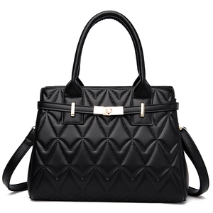 Black quilted tote bag with golden lock and adjustable shoulder strap on white background