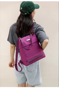 Detail of purple oxford fabric backpack with smooth metal zippers and adjustable straps
