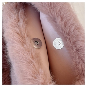 Detail shot of plush pink bucket bag featuring a secure metal magnetic snap closure