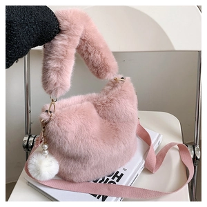 Detail of pink faux fur bucket bag featuring fluffy texture and pearl charm accessory