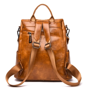 Rear view of brown faux leather backpack showing anti-theft zipper and side pockets