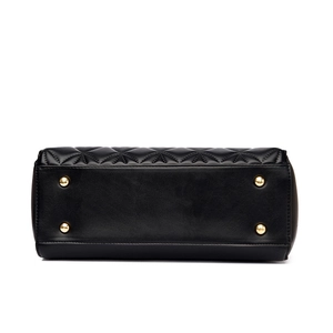 Bottom view of black quilted tote bag featuring protective gold metal feet and fine stitching