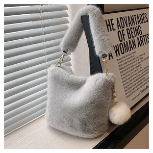 Detail view of grey faux fur bucket bag featuring soft texture and pearl plush charm