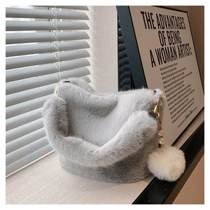 Detail of gray plush bucket bag with fuzzy shoulder strap and pearl faux fur charm