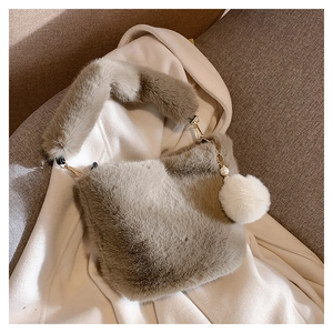 Detail of dark gray faux fur bucket bag with golden hardware and pearl fur charm