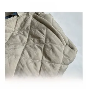 Close-up of diamond-quilted stitching on light khaki tote bag with soft padded texture