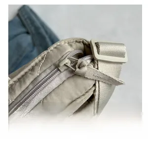 Detail of quilted tote bag featuring smooth zipper and adjustable webbing strap