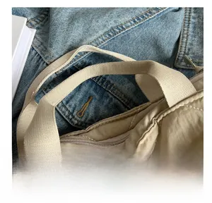 Detail of reinforced nylon handles and quilted diamond pattern on a khaki tote bag