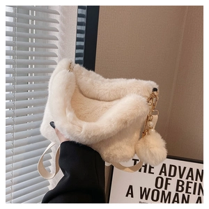 Detail of plush off-white bucket bag featuring soft faux fur texture and pearl charm