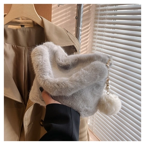Detail of light gray faux fur bucket bag with pearl strap and fluffy pompom charm