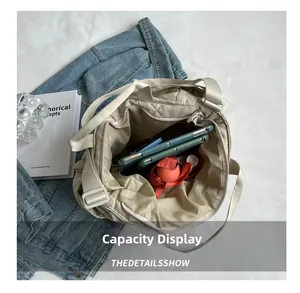 Detailed capacity display of a beige quilted tote bag holding a tablet and umbrella