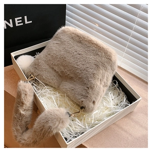 Macro view of plush beige faux fur handbag presented in an elegant gift box set