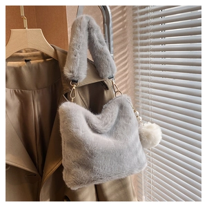 Detail of plush grey faux fur bucket bag with pearl pendant and metal clasp