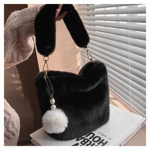 Detail of black plush bucket bag with fuzzy texture, golden hooks and pearl charm