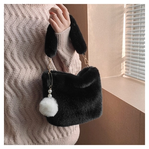 Close-up of black faux fur bucket bag with golden metal hardware and pearl charm