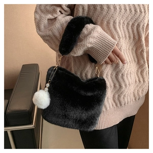 Detail of black faux fur bucket bag with golden hardware and white pearl charm
