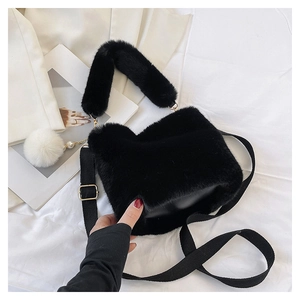 Detail of black faux fur bucket bag with pearl pompom charm and golden hardware