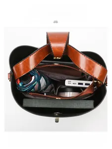 Macro view of large capacity brown leather bucket bag interior with laptop and daily essentials