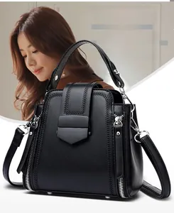 Detailed view of black quilted leather bucket bag with decorative zippers and metal clasp