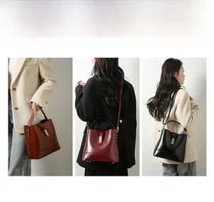 Close-up of stylish bucket bag in brown, wine red, and black with polished gold hardware