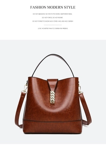 Close-up of vintage brown leather bucket bag with glossy texture and gold buckle detail
