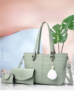 Detailed view of three-piece sage green bucket bag set with crocodile pattern and pompom