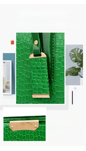 Detail of green crocodile embossed tote bag featuring glossy texture and gold hardware