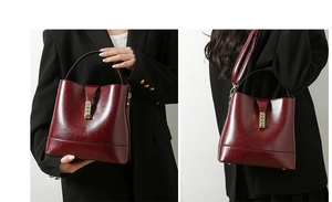 Close-up of wine red leather bucket bag with gold metal hardware and protective feet