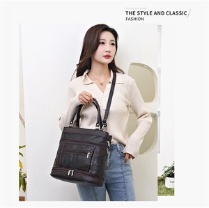 Detail view of dark brown faux leather bag featuring multiple front zipper compartments