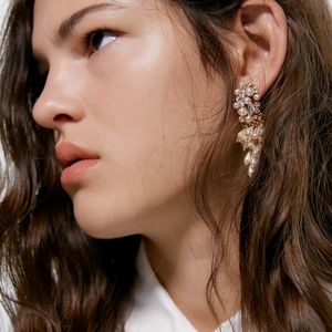 Elegant gold fringe earrings featuring layered white pearls and sparkling rhinestones