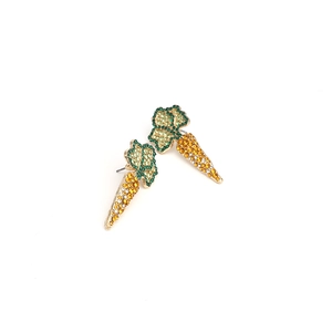 Close-up of carrot-shaped stud earrings with sparkling green and orange rhinestones