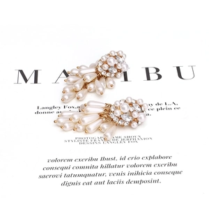 Golden chandelier earrings with pearls and crystals shown from a 45-degree angle