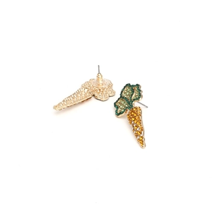 Macro detail of carrot stud earrings with vibrant orange and green crystal rhinestones