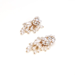 Close-up of golden tassel earrings with sparkling rhinestones and white teardrop pearls