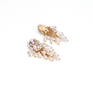 Detail of gold fringe earrings with white pearls and sparkling crystal marquise stones