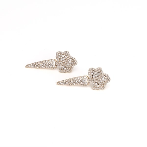 Detailed view of carrot-shaped gold earrings with shimmering white rhinestones