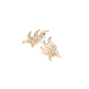 Detailaufnahme goldener Seestern-Ohrringe mit glitzernden Strasssteinen und Steckern