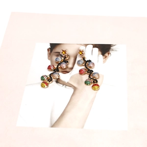 Detailed macro view of star stud earrings with colorful rhinestone spheres on a fashion backdrop